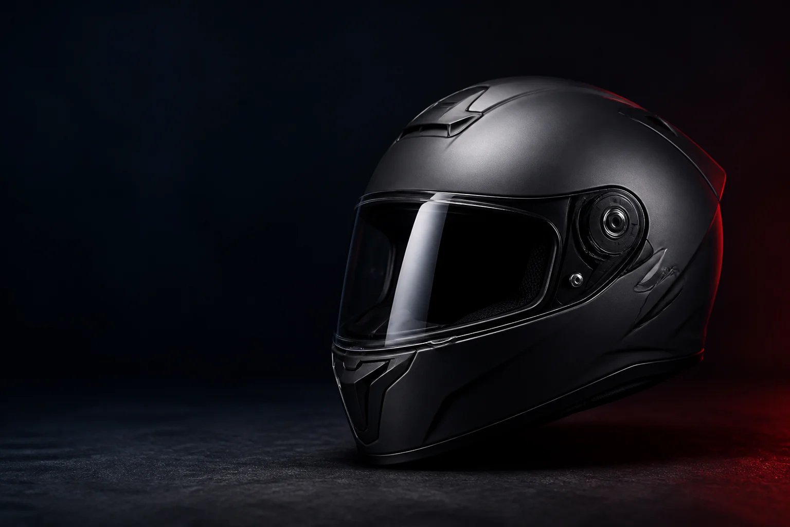 Casco integral negro sobre fondo oscuro con iluminación roja